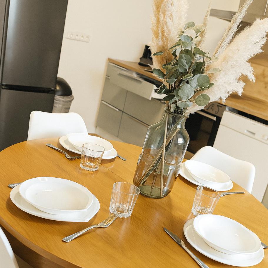 Gedeckter Runder Küchentisch im Ferienhaus mit Küche im Hintergrund